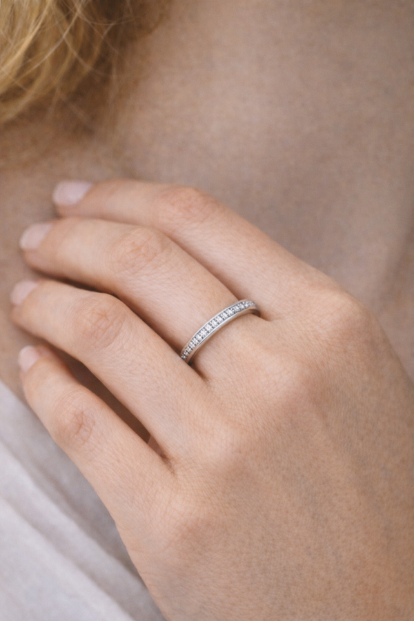 Titaanisormus kivillä naisen sormessa