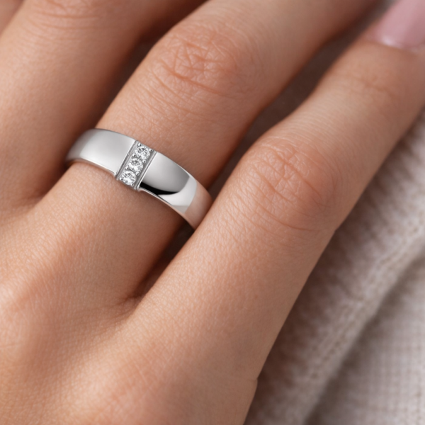 Titaani 6 mm sormus kolmella pystysuoraan asetetulla zirkonialla naisen sormessa