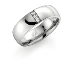 Schalinsin valmistama 6 mm leveä titaanisormus kolmella zirkoniakivellä