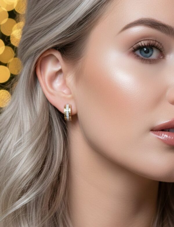 Nainen käyttää kelta- ja valkokultaisia Kohinoor-timanttikorvarenkaita.