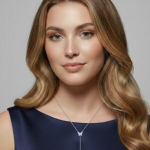 Hopeinen perhoskaulakoru kahdella perhosriipuksella naisen kaulassa.