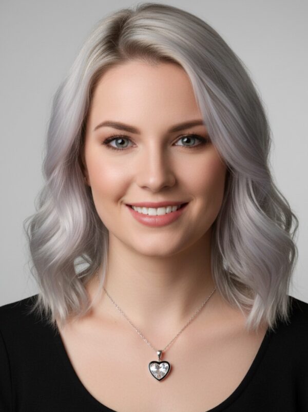 Sydämenmuotoinen zirkoniariipus hopeaketjussa naisen kaulalla.