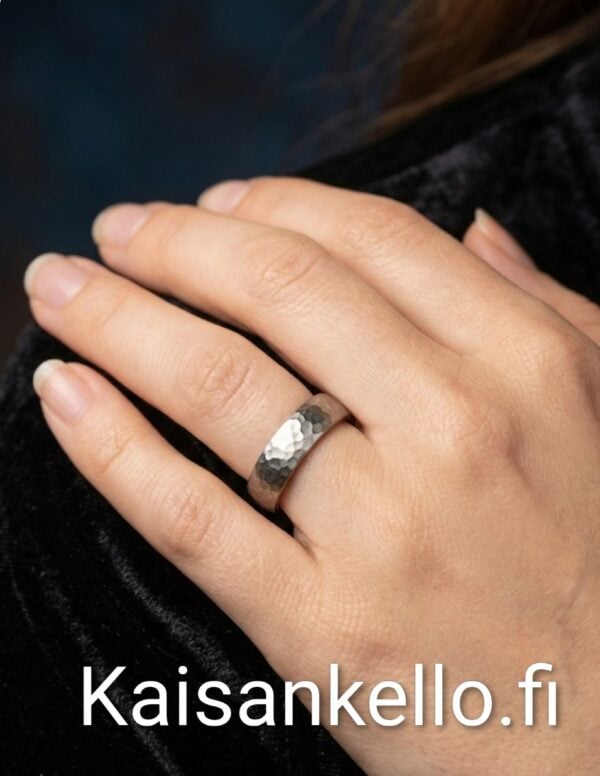 äsin taottu 5 mm titaanisormus sormessa – mattapintainen taottu pinta.