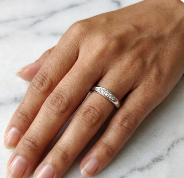 Valkokultainen timanttisormus kädessä