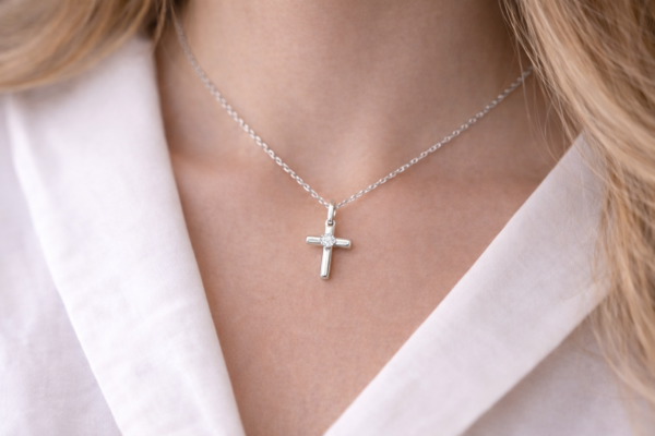 Siro ja ajaton putkimallinen ristiriipus, jossa kirkas zirkoniakivi keskellä.