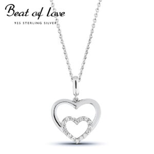 Hopeinen tuplasydänkaulakoru, jossa pienempi sydän koristeltu zirkoneilla.